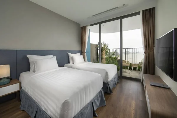 Phòng ngủ Twin với 02 giường đơn, ban công với bàn trà, hướng nhìn ra vịnh Lan Hạ